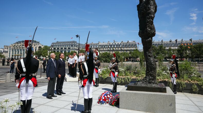 France's President Emmanuel Macron, center right, with Charles Dreyfus grandson of Alfred Dreyfus during a tribute ceremony to Captain Alfred Dreyfus on the first national day dedicated to the recognition of his innocence by the Court of Cassation in 1906, and the fight against the resurgence of antisemitism, 120 years later, on the Ile de la Cite near the Cour de Cassation in Paris, Sunday, July 12, 2026. (Thomas Samson/Pool Photo via AP)