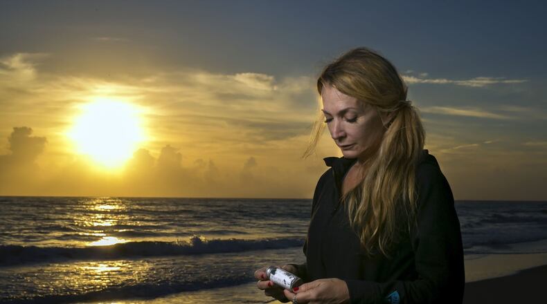 County Attorney Denise-Marie Nieman, of Jupiter, holds a bottle with a message she found recently while walking the beach with friends north of the Jupiter Reef Club on December 18, 2015. (Richard Graulich / The Palm Beach Post)