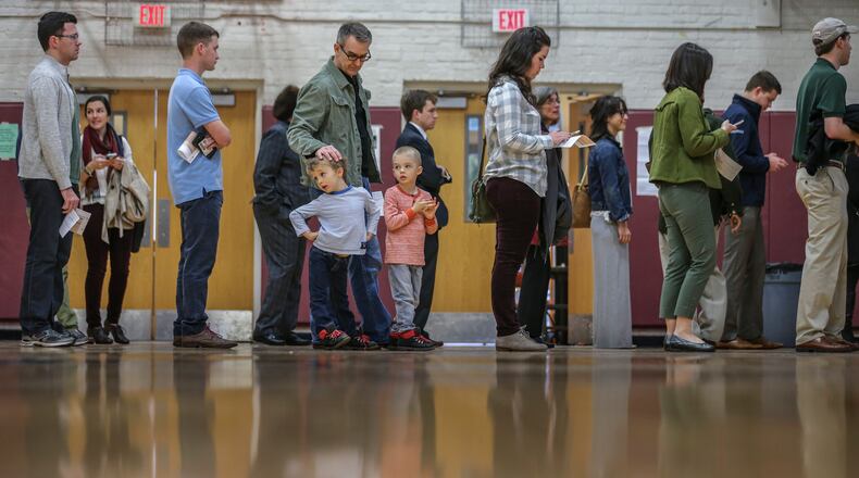 SECONDARY PHOTO - March 1, 2016 Atlanta: Steve Amos with sons, Cy-5 (left) and Leon-5 (right) join voters in line to vote at Henry W. Grady High School in Atlanta. Voters in Georgia cast their ballots Tuesday, Mar. 1, 2016 in the presidential primary as Democrat Hillary Clinton and Republican Donald Trump look to leverage their leads and their rivals try to stop their marches to nomination. Georgia offers the second-biggest delegate haul of the dozen states holding votes on Tuesday, trailing only Texas in clout on Super Tuesday. Polls showed that both Clinton and Trump had sizable advantages going into Tuesday's election in Georgia. Georgia's "winner-takes-most" Republican delegate rules adds an extra layer of intrigue to the night's contest. Candidates can only get delegates if they reach 20 percent of the statewide vote or if they finish first or second in one of Georgia's 14 congressional districts. JOHN SPINK / JSPINK@AJC.COM