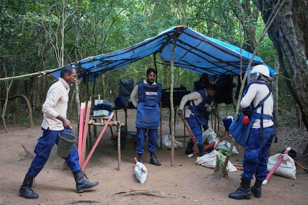 Vilvaraj Vinothan, second left, who works for the demining agency Mine Advisory Group, prepares to work in a contaminated mining area in Mankulam, Sri Lanka, Wednesday, April 2, 2025. (AP Photo/Eranga Jayawardena)