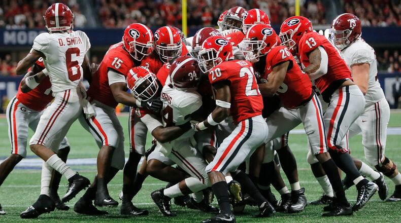 Alabama Crimson Tide running back Damien Harris (34) gets swarmed by Georgia's defense in the first quarter of the SEC Championship game Saturday, Dec. 1, 2018, at Mercedes-Benz  Stadium in Atlanta, GA. BOB ANDRES / BANDRES@AJC.COM