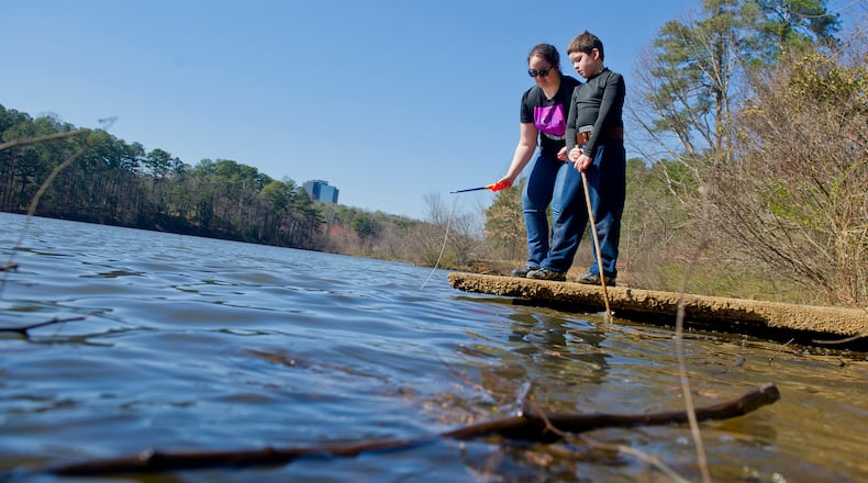 Elisabeth Cortez (left) and her brother Quinn play by the edge of the pond at Murphey Candler Park in Brookhaven in 2014.    JONATHAN PHILLIPS / SPECIAL