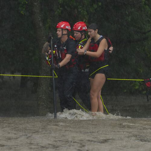 Members of the Boerne Fire Dept. rescue a woman from flood waters on Wednesday, July 15, 2026, in Boerne, Texas. (AP Photo/Darren Abate)