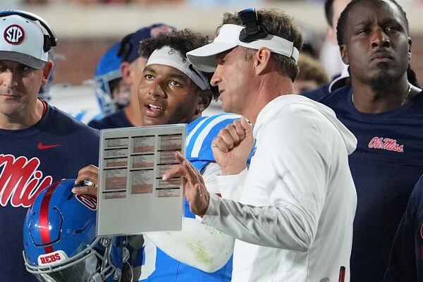 Mississippi head coach Lane Kiffin, right, confers with quarterback Trinidad Chambliss during an NCAA college football game against Florida, Saturday, Nov. 15, 2025, in Oxford, Miss. (Rogelio V. Solis/AP)