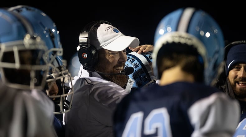 Cambridge Head Coach Craig Bennett hugs players during a GHSA high school football game between Cambridge and South Paulding at Cambridge High School in Milton, GA., on Saturday, November 13, 2021. (Photo/Jenn Finch)
