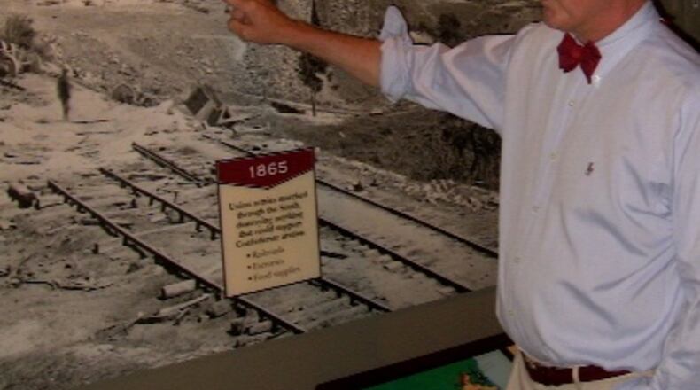 Steve Davis, a local historian and author, stands in front of photo of the wrecked train that held the Confederate army’s ammunition reserve, blown up on the night of Sept. 1-2, 1864, as the Rebel army evacuated Atlanta. Davis has briefed Jimmy Carter and Carter’s family on historical events that occurred where the Carter Center now stands.