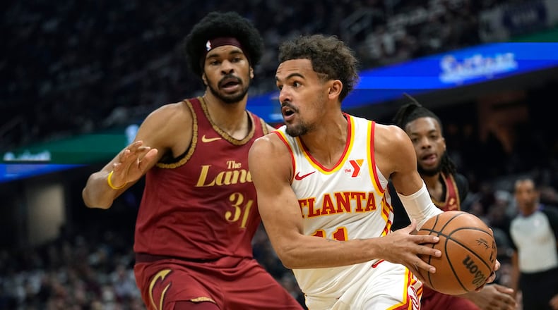 Atlanta Hawks guard Trae Young, right, drives around Cleveland Cavaliers center Jarrett Allen (31) in the first half of an In-Season Tournament NBA basketball game, Tuesday, Nov. 28, 2023, in Cleveland. (AP Photo/Sue Ogrocki)
