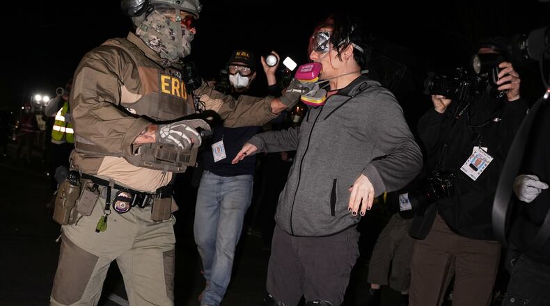 A federal immigration officer pulls the respirator mask from a protester outside Delaney Hall detention center Thursday, May 28, 2026, in Newark, N.J. (AP Photo/Angelina Katsanis)
