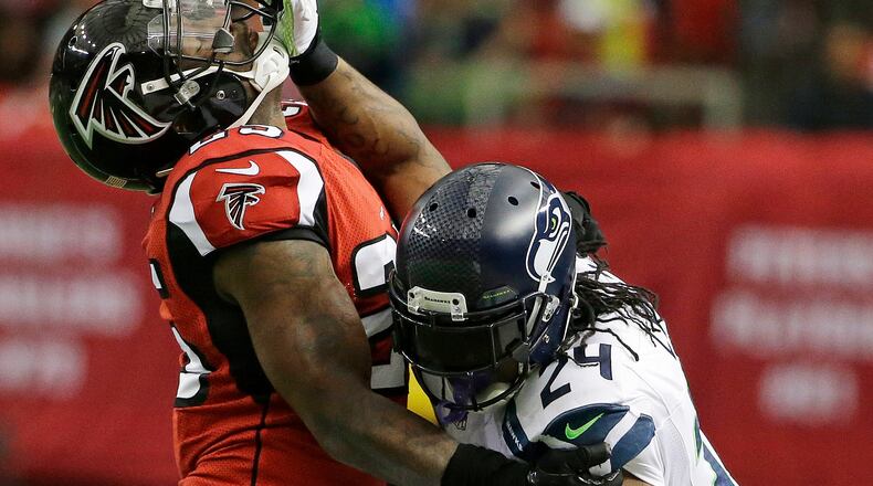 Seattle Seahawks running back Marshawn Lynch (24) strait arms Atlanta Falcons strong safety William Moore (25) during the first half of an NFL football game, Sunday, Nov. 10, 2013, in Atlanta. (AP Photo/David Goldman)