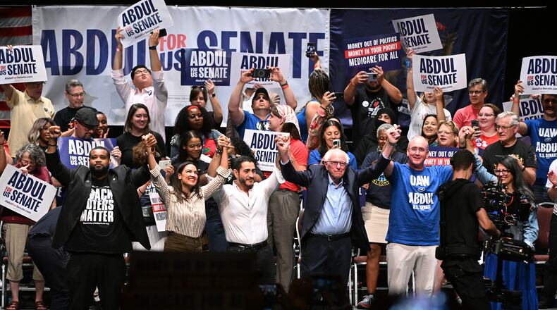 From left foreground, Michigan state Rep. Donavan McKinney, D-Detroit, U.S. Rep. Alexandria Ocasio-Cortez, D-N.Y., Michigan Democratic U.S. Senate primary candidate Abdul El-Sayed, U.S. Sen. Bernie Sanders, I-VT., United Auto Workers President Shawn Fain, and U.S. Rep. Rashida Tlaib, D-Mich. join hands together following a campaign rally for El-Sayed, Saturday, July 18, 2026, in Detroit. (AP Photo/Jose Juarez)