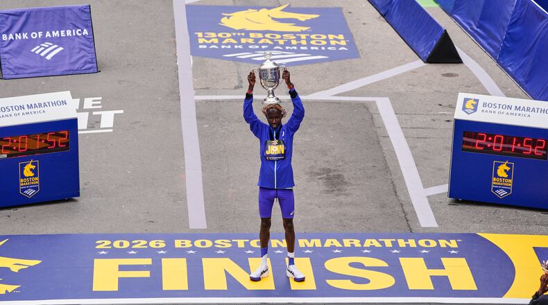 John Korir of Kenya, hoist the trophy after winning the Boston Marathon, Monday, April 20, 2026, in Boston. (AP Photo/Charles Krupa)
