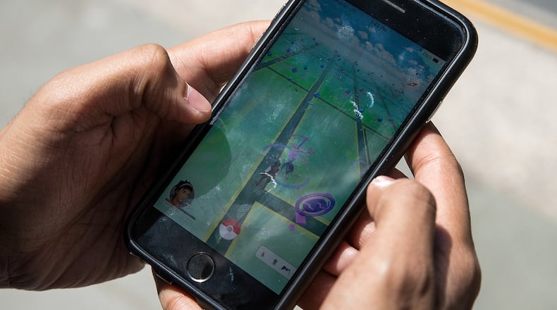NEW YORK, NY - JULY 11: Sameer Uddin plays Pokemon Go on his smartphone outside of Nintendo's flagship store, July 11, 2016 in New York City. The success of Nintendo's new smartphone game, Pokemon Go, has sent shares of Nintendo soaring. (Photo by Drew Angerer/Getty Images)