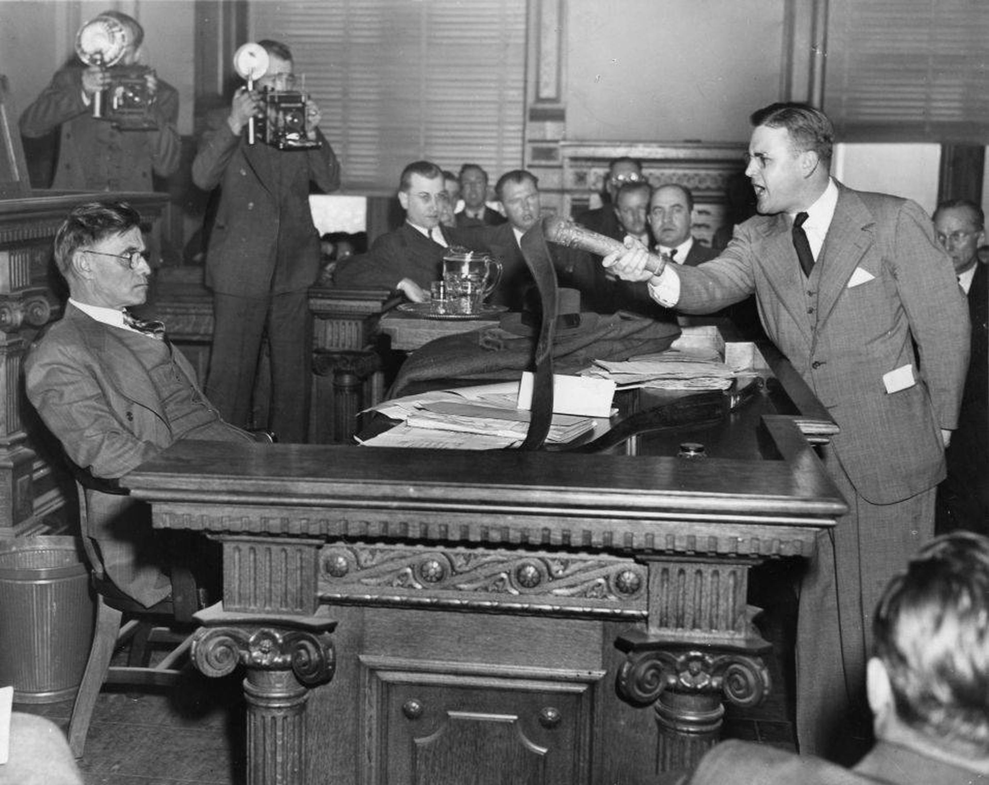 Prosecutor Dan Duke (right) confronts Gov. Gene Talmadge with a whip that was used by the Ku Klux Klan to beat African Americans. After Duke won convictions against several Klansmen, Talmadge signaled he would grant them clemency. (AJC file)