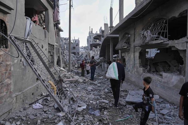 Palestinians inspect the rubble of homes destroyed by Israeli airstrikes in Jabalia, northern Gaza Strip, on Wednesday, May 14, 2025. According to local hospitals, 48 people were killed in the strikes, including 22 children. (AP Photo/Jehad Alshrafi)