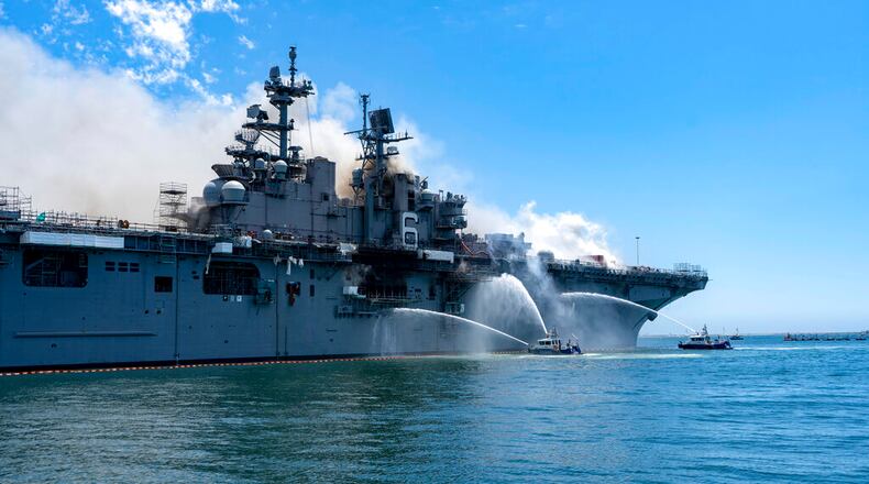 In a photo provided by the U.S. Navy, Port of San Diego Harbor Police boats fight a fire aboard the USS Bonhomme Richard at Naval Base San Diego on Sunday, July 12, 2020. Twenty-one people suffered minor injuries in an explosion and fire on the ship, military officials said.