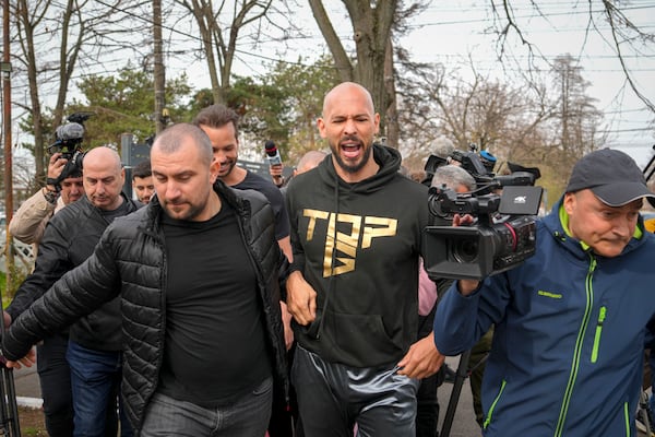 Andrew Tate reacts while speaking to media after checking in at a police station as part of his judicial control, which requires him to appear before judicial authorities in Romania when summoned, after returning from the United States, in Voluntari, Romania, Monday, March 24, 2025. (AP Photo/Vadim Ghirda)