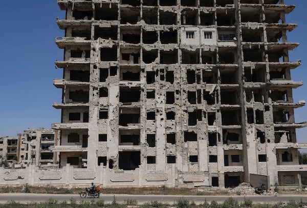 A restored apartment, top center, can be seen in an otherwise severely damaged apartment building in the Al-Waer neighborhood of Homs, Syria, Tuesday, May 13, 2025. (AP Photo/Ghaith Alsayed)