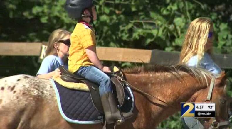 Charlie, a 5-year-old with special needs, rides a horse at Rising Hope Farm on Tuesday. The farm is part of Special Equestrians of Georgia.