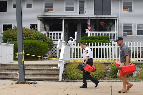 Investigators, front, remove boxes containing patient medications from the Gabriel House assisted living facility, behind, following a fire that resulted in multiple fatalities, in Fall River, Mass., Monday, July 14, 2025. (AP Photo/Steven Senne)
