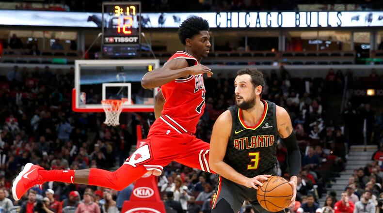 Hawks guard Marco Belinelli (3) gets Chicago Bulls guard Justin Holiday off his feet. The Bulls won 91-86. (AP Photo/Charles Rex Arbogast)
