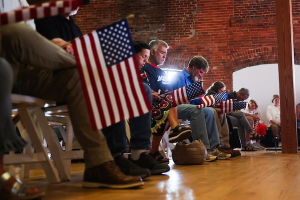 People bow their heads in prayer during a rally for Republican nominee for governor Rick Jackson at The Bibb Mill Event Center in Columbus on Thursday. (Abbey Cutrer/AJC)