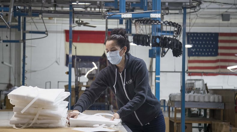Sidia Ventura folds isolation medial gowns as she prepares to box them at Echota Fabrics, Inc. in Calhoun on April 8, 2020. Echota normally produces fabrics for curtains and bedding, but is participating in an informal regional consortium making medical gowns and fabric face masks for health-care workers responding to the COVID19 pandemic. (ALYSSA POINTER / ALYSSA.POINTER@AJC.COM)