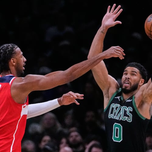 Boston Celtics forward Jayson Tatum (0) reaches up to block a pass by Washington Wizards center Alex Sarr (20) during the first half of an NBA basketball game, Saturday, March 14, 2026, in Boston. (AP Photo/Charles Krupa)