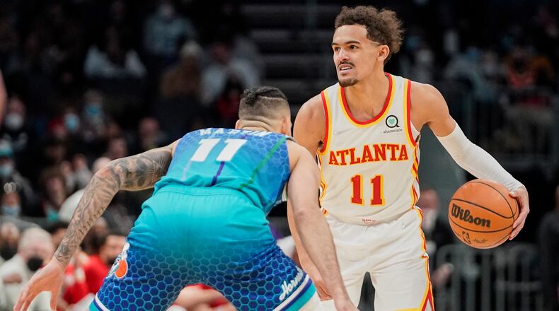 Atlanta Hawks guard Trae Young brings the ball upcourt against Charlotte Hornets forward Cody Martin during the second half of an NBA basketball game Sunday, Jan. 23, 2022, in Charlotte, N.C. (AP Photo/Rusty Jones)