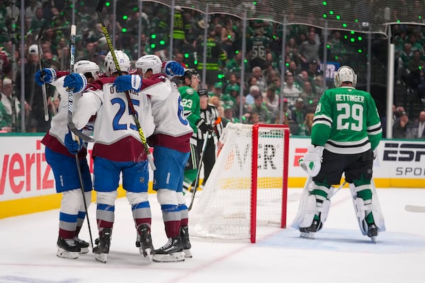 Colorado Avalanche players celebrate a goal by Logan O'Connor (25) as Dallas Stars goaltender Jake Oettinger (29) skates on his crease during the second period in Game 2 of a first-round NHL hockey playoff series Monday, April 21, 2025, in Dallas. (AP Photo/Julio Cortez)