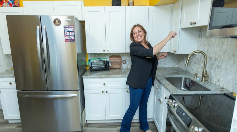 Allison Hill prepares to store groceries she brought to Lucero Liborio in her southwest Atlanta home. Hill and her family renovated Liborio's kitchen recently.  PHIL SKINNER FOR THE ATLANTA JOURNAL-CONSTITUTION