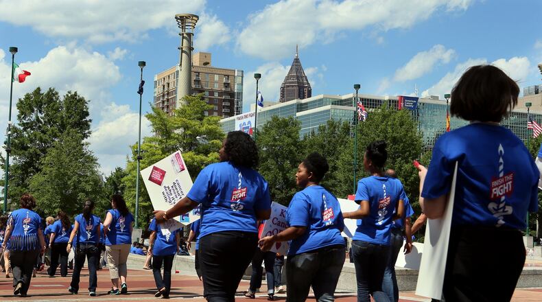 An estimated 450 American Cancer Society employees, volunteers and supporters march through Centennial Olympic Park in downtown Atlanta after a rally to celebrate the organization’s 100th birthday in 2013. The nonprofit announced layoffs June 10, 2020. File photo. (PHIL SKINNER/AJC)