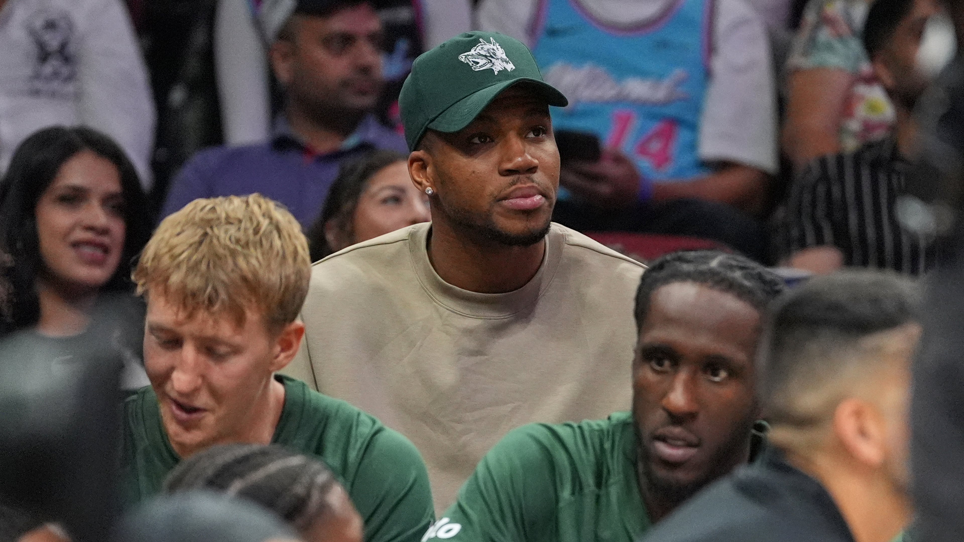 Milwaukee Bucks forward Giannis Antetokounmpo, who is recovering from COVID-19, sits behind his team's bench as he watches the second half of a preseason NBA basketball game against the Miami Heat, Monday, Oct. 6, 2025, in Miami. (AP Photo/Rebecca Blackwell)