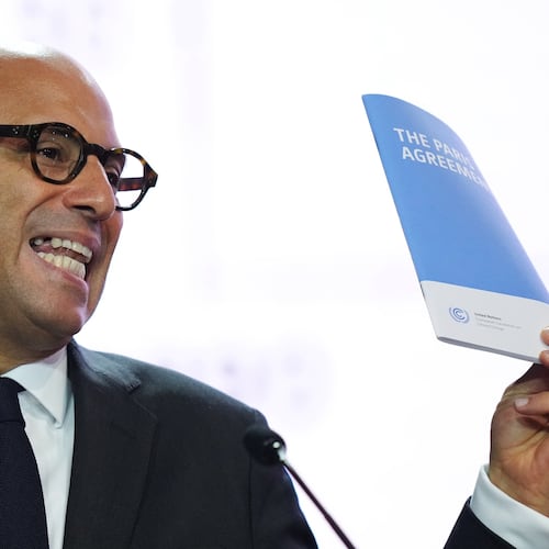 Simon Stiell, United Nations climate chief, holds up a pamphlet that reads The Paris Agreement at the COP30 U.N. Climate Summit, Monday, Nov. 10, 2025, in Belem, Brazil. (AP Photo/Fernando Llano)