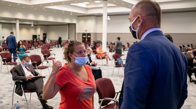200716-Suwanee-Mary Williams, a parent who is opposed to mandatory face mask requirements, talks with Gwinnett County Public Schools board member Steven Knudsen before the start of the regular board meeting Thursday evening July16, 2020. Ben Gray for the Atlanta Journal-Constitution