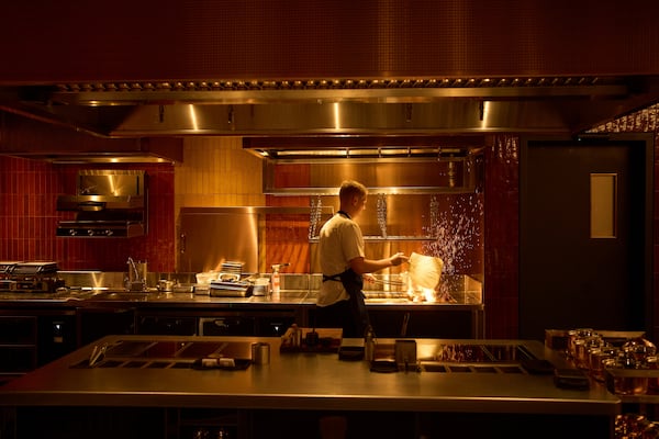 A chef lights charcoal at FZN Restaurant on Palm Jumeirah in Dubai, United Arab Emirates, Friday, June 13, 2025. (AP Photo/ Fatima Shbair)