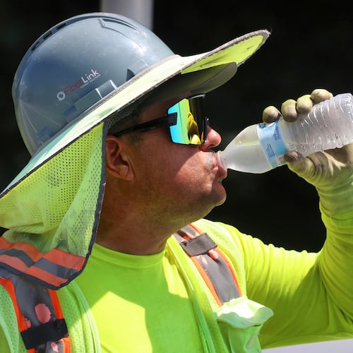 FILE - Fiber optic worker Hareberto Cruz cools off during a break at an installation project on S.R. 434 at S.R. 417 in Winter Springs, Fla., as afternoon temperatures hit the high 90s, Monday, July 28, 2025. (Joe Burbank/Orlando Sentinel via AP, file)