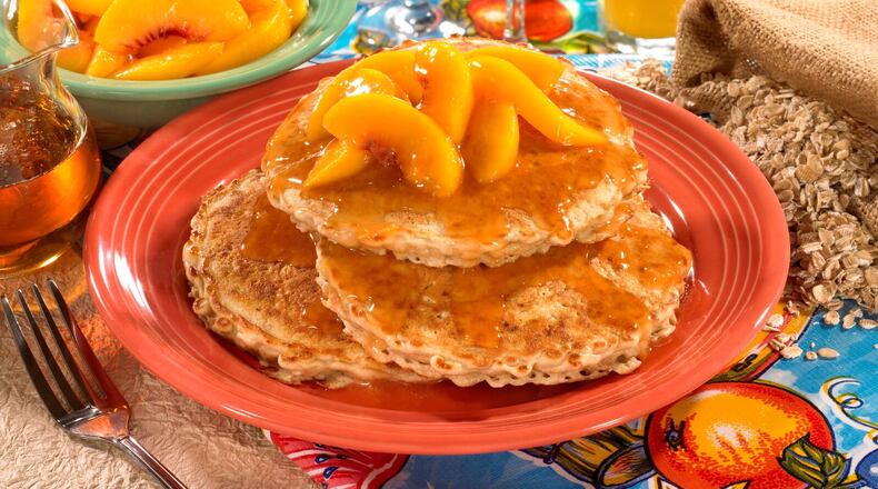 The Organic Oatmeal Pancakes with Peaches are three cakes topped with warm peach compote. These are an original Flying Biscuit menu item that has been offered to guests since the first location opened in 1993. / The Flying Biscuit Cafe, 10 Atlanta area locations. flyingbiscuit.com / Photo credit: Sara Hanna Photography