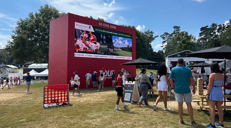 Some fans at East Lake Golf Club gather around a large screen that showed the Georgia-Clemson college football game during the third round of the Tour Championship.