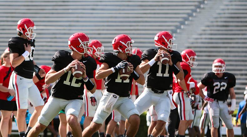 Georgia quarterbacks Brice Ramsey (12), Nick Robinson (17), and Greyson Lambert (11) throw the ball during a Bulldogs' spring practice session in Athens.