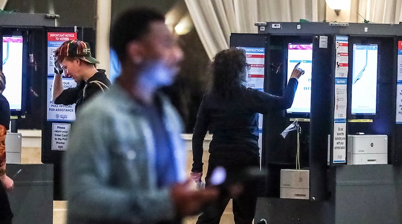 December 6, 2022 Atlanta: Poll workers (left to right) Alexandra Almeter, Gamble Everett, Erik Coleman and Sarah Zaslaw prepare the voting machines before the polls opened on Tuesday, Dec. 6, 2022 at the Park Tavern located at 500 10th Street NE in Atlanta. ItÕs been a marathon, not a sprint, for Georgia voters to settle on a long-term replacement for the late U.S. Sen. Johnny Isakson, who resigned from the Senate in 2019 amid ongoing health concerns. One gubernatorial appointment and five statewide elections later, TuesdayÕs U.S. Senate runoff election in Georgia will finally decide who will represent Georgia in the Senate for a full, six-year term. In WalkerÕs final speech at the GovernorÕs Gun Club, he told a small crowd, ÒThe best thing IÕve ever done, including the Heisman Trophy, and the Horatio Alger award, the best thing IÕve ever done is run for office right here.Ó Late Monday night, Warnock Tweeted a final message. ÒIÕve said it before and IÕll say it again, I canÕt have Herschel Walker representing my mama.Ó Most of the runoff polling put Warnock, the Democratic incumbent, slightly ahead of, but statistically tied with his Republican challenger. (John Spink / John.Spink@ajc.com)