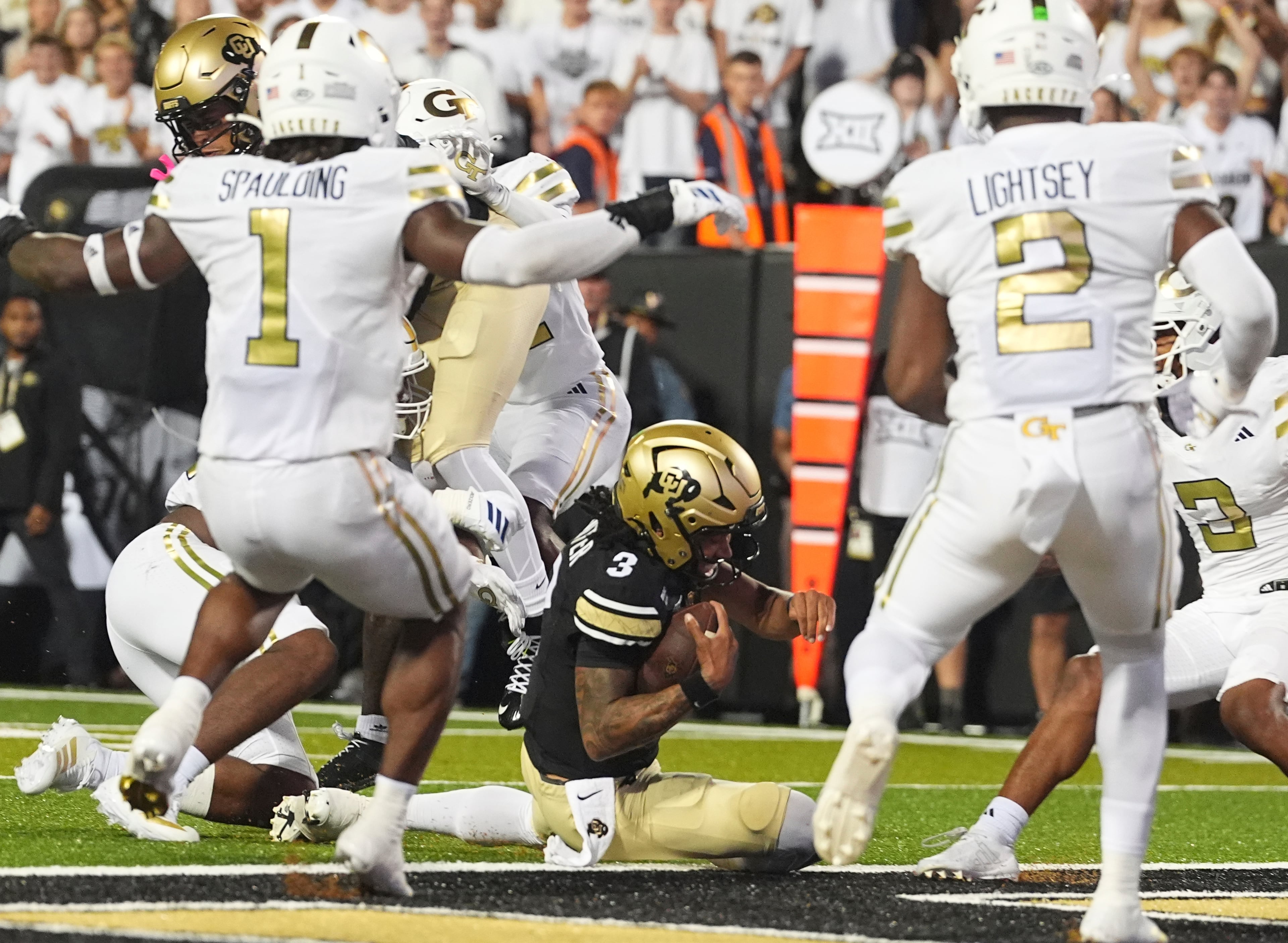 Colorado quarterback Kaidon Salter (3) slides into the end zone for a touchdown between Georgia Tech linebackers Cayman Spaulding (1) and E.J. Lightsey (2) in the second half of an NCAA college football game Friday, Aug. 29, 2025, in Boulder, Colo. (AP Photo/David Zalubowski)