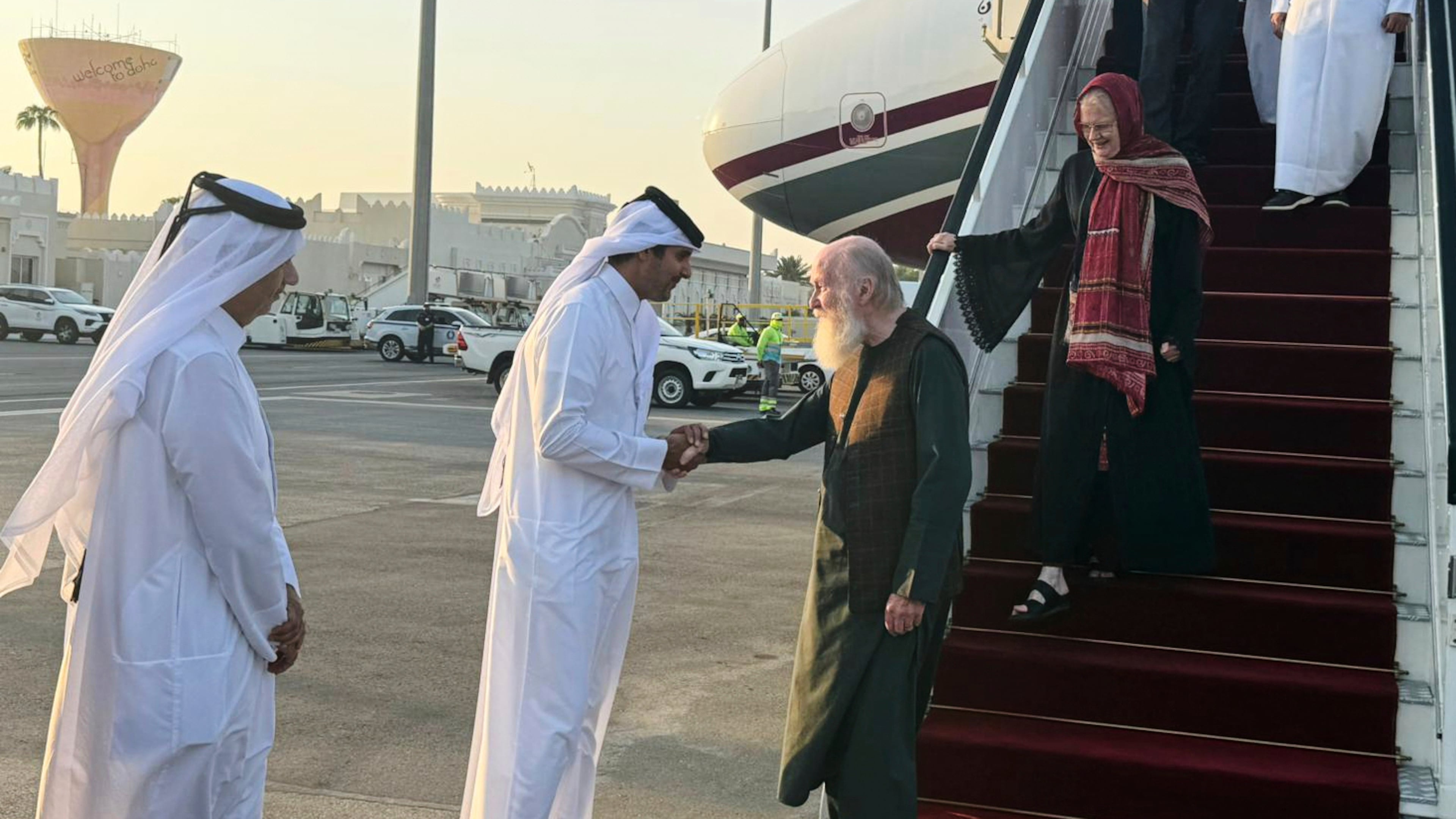 A Qatari official welcomes the released British couple, Barbie and Peter Reynolds, as they step off the plane upon their arrival in Doha, Qatar, Friday, Sept. 19, 2025. (AP Photo/Najib Jubain)