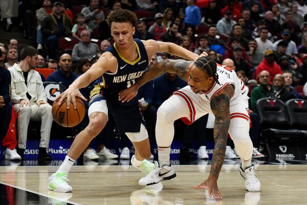 New Orleans Pelicans' Dyson Daniels (11) battles Chicago Bulls' DeMar DeRozen (11) for a loose ball during the second half of an NBA basketball game Saturday, Dec. 2, 2023, in Chicago. Chicago won 124-118. (AP Photo/Paul Beaty)
