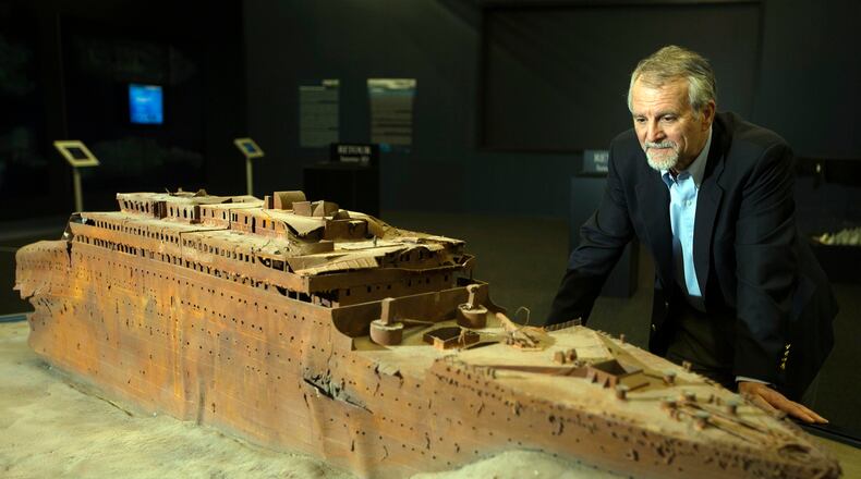 Paul-Henri Nargeolet, director of a deep ocean research project dedicated to the Titanic, poses next to a miniature version of the sunken ship inside a new exhibition, at 'Paris Expo', on May 31, 2013, in Paris. (JOEL SAGET/AFP via Getty Images)