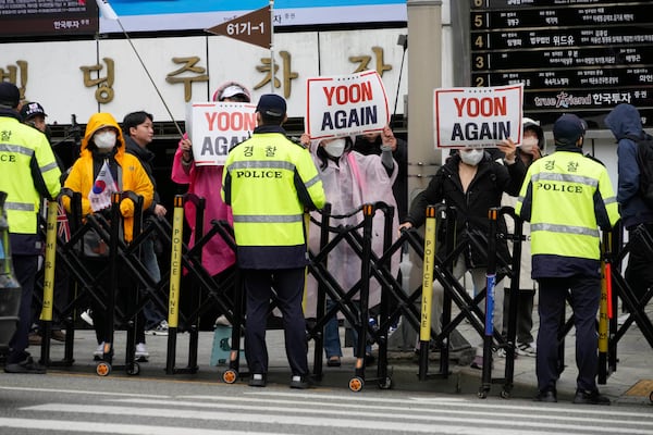Supports of South Korea's ousted President Yoon Suk Yeol stand to call for the cancellation of his removal in front of the Seoul Central District Court in Seoul, South Korea, Monday, April 14, 2025. (AP Photo/Ahn Young-joon)
