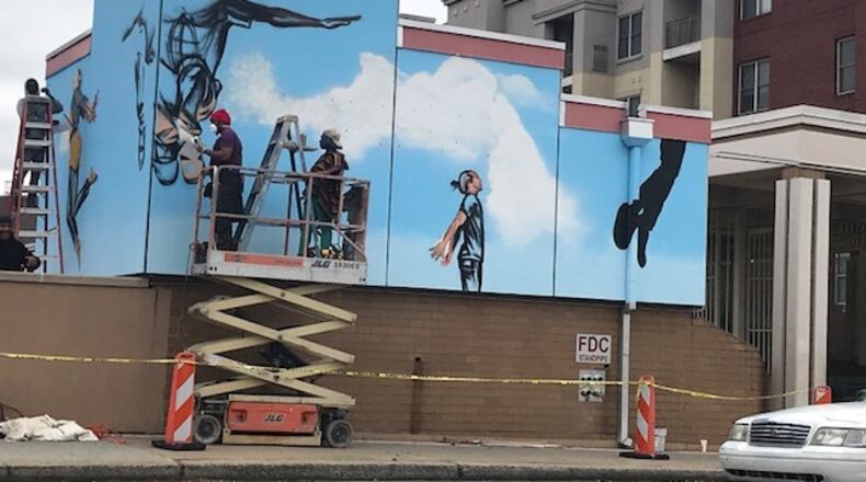Fahamu Pecou with support artists Denisha Claxton and Fabian Williams worked on a mural called "The People Could Fly" at the Ashby Street MARTA station as part of the Transformation Alliance, coordinated by WonderRoot. CONTRIBUTED BY JOY BARNES