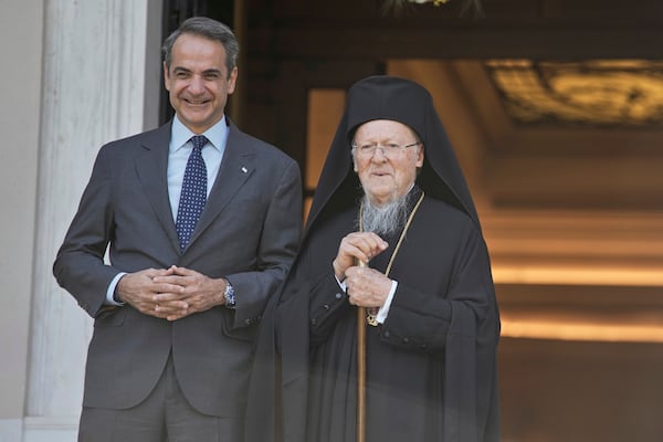 Greece's Prime Minister Kyriakos Mitsotakis, left, and the Orthodox Ecumenical Patriarch Bartholomew pose for photographers before their meeting in Athens, on Thursday May 8, 2025. (AP Photo/Petros Giannakouris)