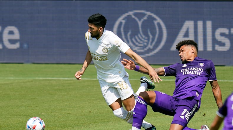 Atlanta United midfielder Marcelino Moreno, left, gets control of the ball in front of Orlando City midfielder Junior Urso (11) during the first half of an MLS soccer match, Saturday, April 17, 2021, in Orlando, Fla. (AP Photo/John Raoux)
