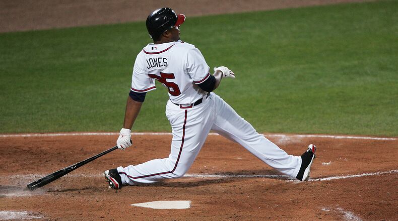 Former 10-time Gold Glove winner Andruw Jones, shown here with his distinct follow-through after a home run, will serve as a guest instructor at Braves spring training for nearly two weeks. (POUYA DIANAT/AJC file photo)