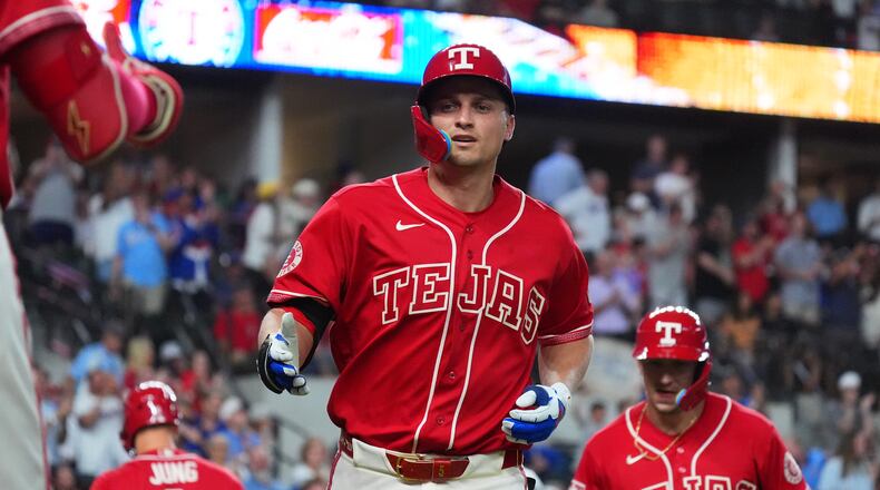 Texas Rangers' Corey Seager, center, jogs to the dugout after hitting a home run during the sixth inning of a baseball game against the Cleveland Guardians, Friday, June 5, 2026, in Arlington, Texas. (AP Photo/LM Otero)